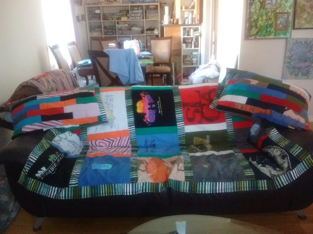 Living room couch covered with a quilt and pillow cases that were DIY. 