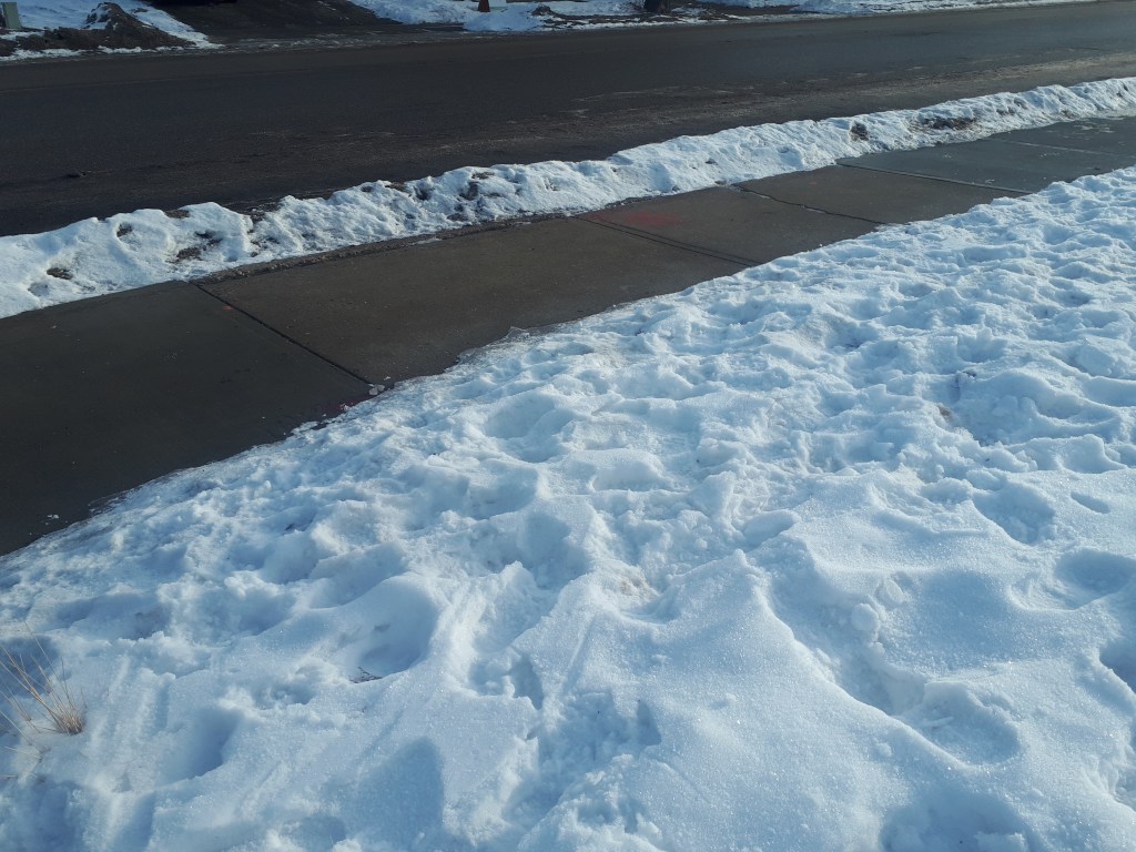 Outdoor sidewalk shovelled clearly of snow during winter. 