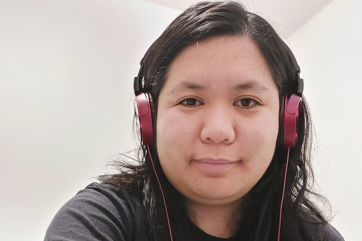 Giselle wearing a black T shirt and red headphones