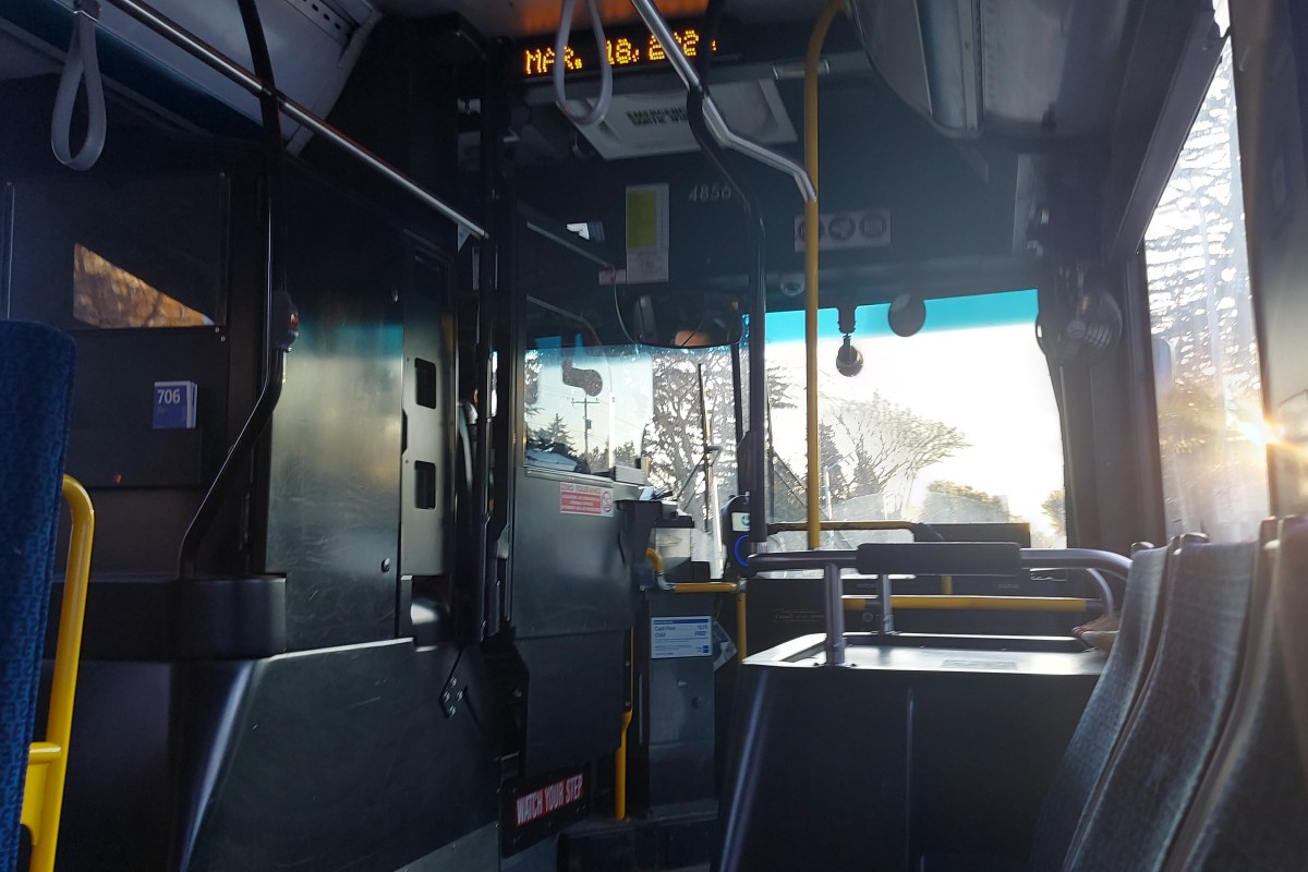 The inside of the regular sized Edmonton transit bus. The front area near the driver's compartment has no information or printed signage about the Transit Watch contact line.